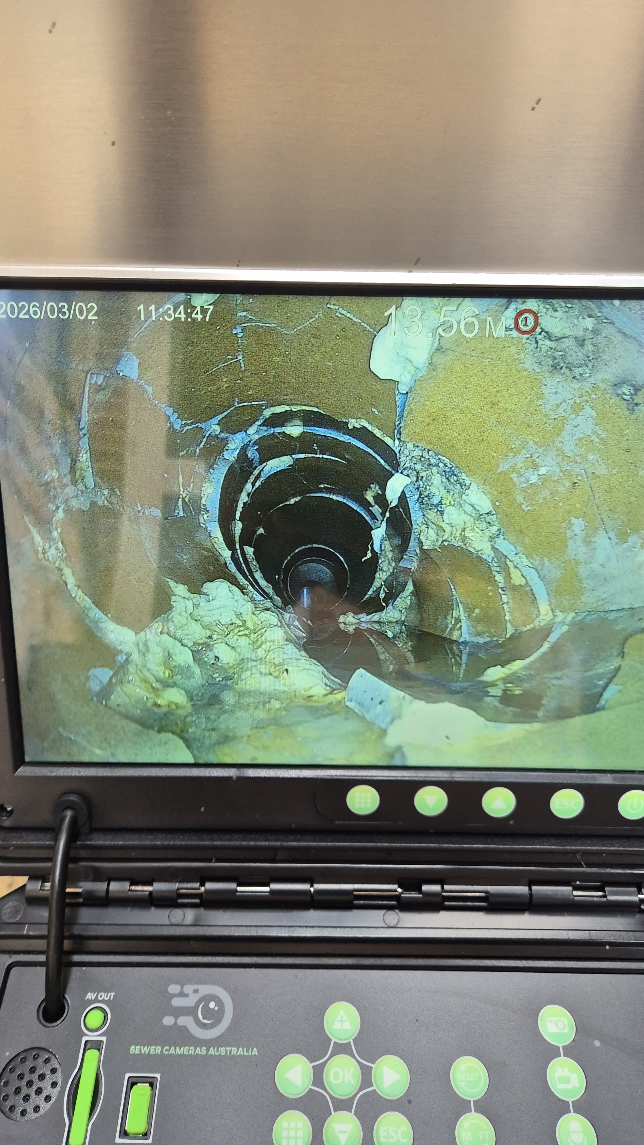 CCTV drain camera screen showing a damaged pipe junction at 13.56 metres down the line